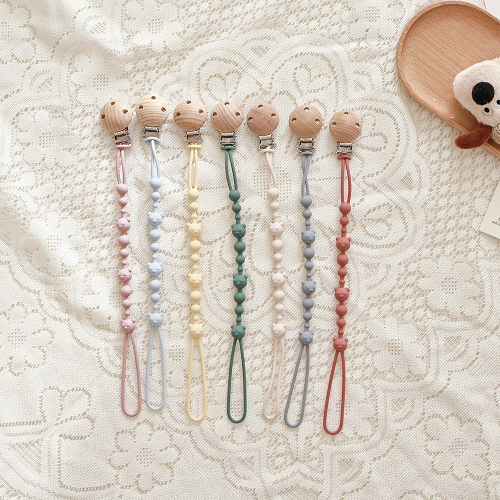 Silicone Dummy Clip, Beaded Soother Holder with Beech Wood Clip & Bear, Face Beads, 22 cm, 7 Colours, styled on a shelf